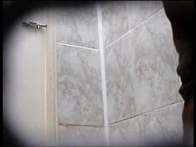 Amateur in high boots sits pissing in public toilet