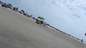 Saucy babe walks around the city beach in a colorful bikini