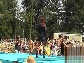 Strippers work the stage at an outdoor party