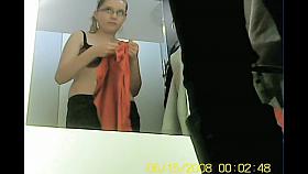 Girl in black bra tries new cloths in the fitting room