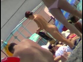 Sexy blonde chick is sitting naked by the sea and relaxing