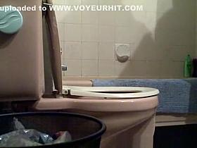 Girl lifts toilet seat and seats to take a pee