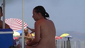 Nudist video at the beach has shy girl playing in the water