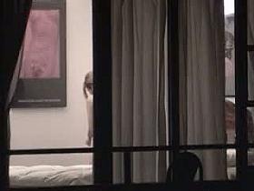 Sexy blonde stripping next to a window caught on voyeur cam