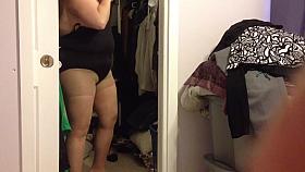 putting on her black girdle covering her big boobs.
