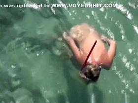 Nudist woman swimming in the water