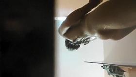 Spying over and under the shower walls on a tanned girl