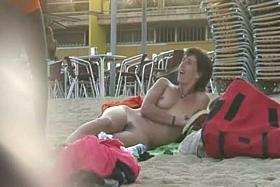 Short haired sweetie filmed on a nudist beach