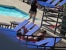 Sexy babe relaxes by the pool
