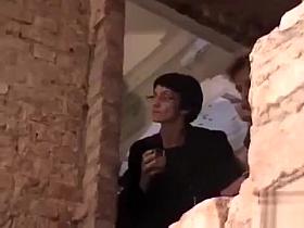 Naked female bodies covered in mud at art show