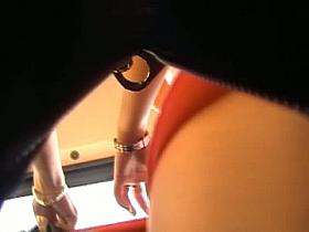 Lady in pink walks with her friend as a voyeur follows them to take underskirt videos