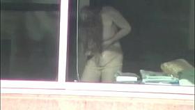 Sea woman getting dressed in window voyeur