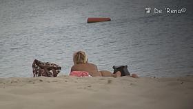 Voyeur spies on a perky breasted MILF on a nudist beach