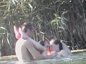 Curvaceous slug receiving two massive cock on the nudist beach