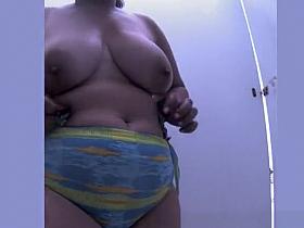 Chubby woman changing in beach cabin