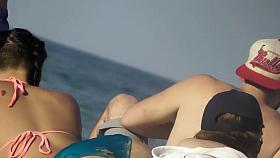 Asian teen girl bends over on beach