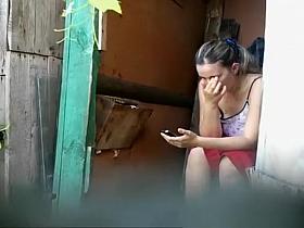 Woman takes a pee in old wood toilet