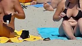 Beach voyeur 02 - A topless gril and her large boobs ally