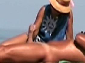 Hot lady gives a handjob at a beach