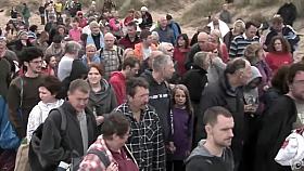 Hundreds of nudist people running into the sea naked