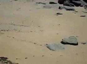 Two nude girls sun bathing on beach.