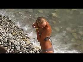 Voyeur on public beach. The suntanned girl rides on the guy