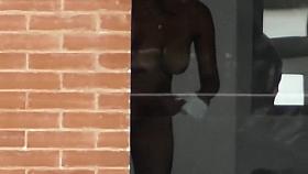 Busty woman filmed in secret while naked next to the window