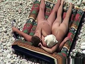 Nudist couple relaxing and sunbathing