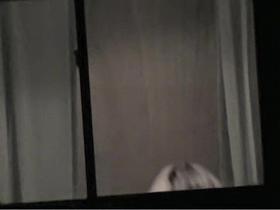 Topless bimbo is kinkily voyeured through the window