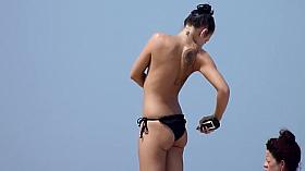 Classless chick with big tits and tattoo's on a beach