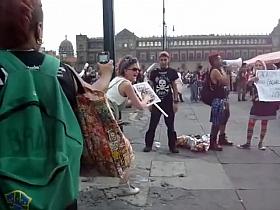 Female agitator pees and poops on a poster at a rally in protest to the government
