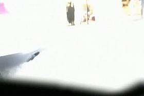 Upskirt spy cam shot of a sexy blonde sitting on a curb.