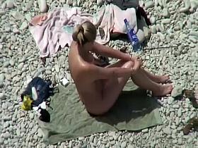 Nude milf on a beach and her hairy pussy