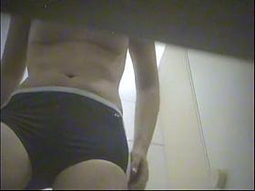 A girl in the swimming pool dressing cabin gets naked and displays her tits