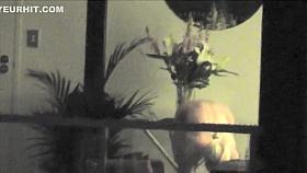 Busty blonde bombshell changes her clothes near the window