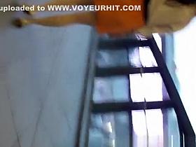 Woman in orange skirt upskirted