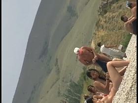 Nudist girls splashing around and playing in shallow water