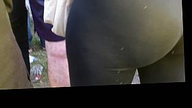 A hot brunette at a concert with black spandex and a juicy big ass