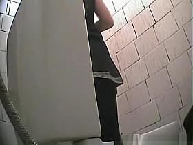 Brunette chick spied in public toilet pissing
