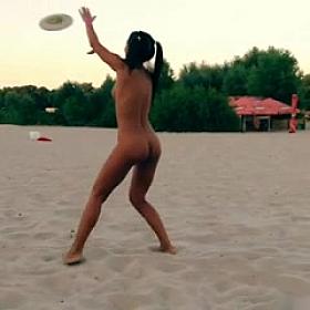 Nude Innuska playing frisbee on the beach
