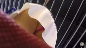 Upskirt of a Pink thong under wite miniskirt.