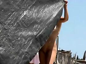 Clumsy nude girl trying to fix a tent