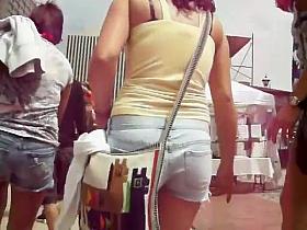 Following a girl in short jeans pants