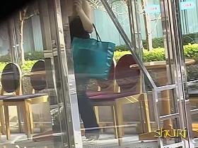 Slim Asian girl engaged into boob sharking on the street.