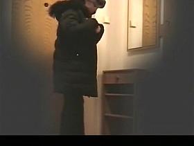 Woman undressing in apartment hall