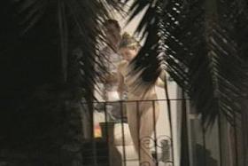 Naked in front of balcony door