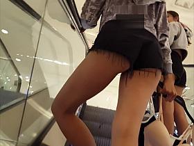 Candid voyeur two hot teens showing cheeks in shorts mall