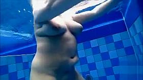 Curvy naked body floats in the pool