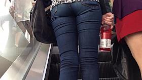 Denim jeans ass going up the escalator