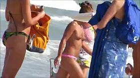 Topless legal age teenager playing at beach in water